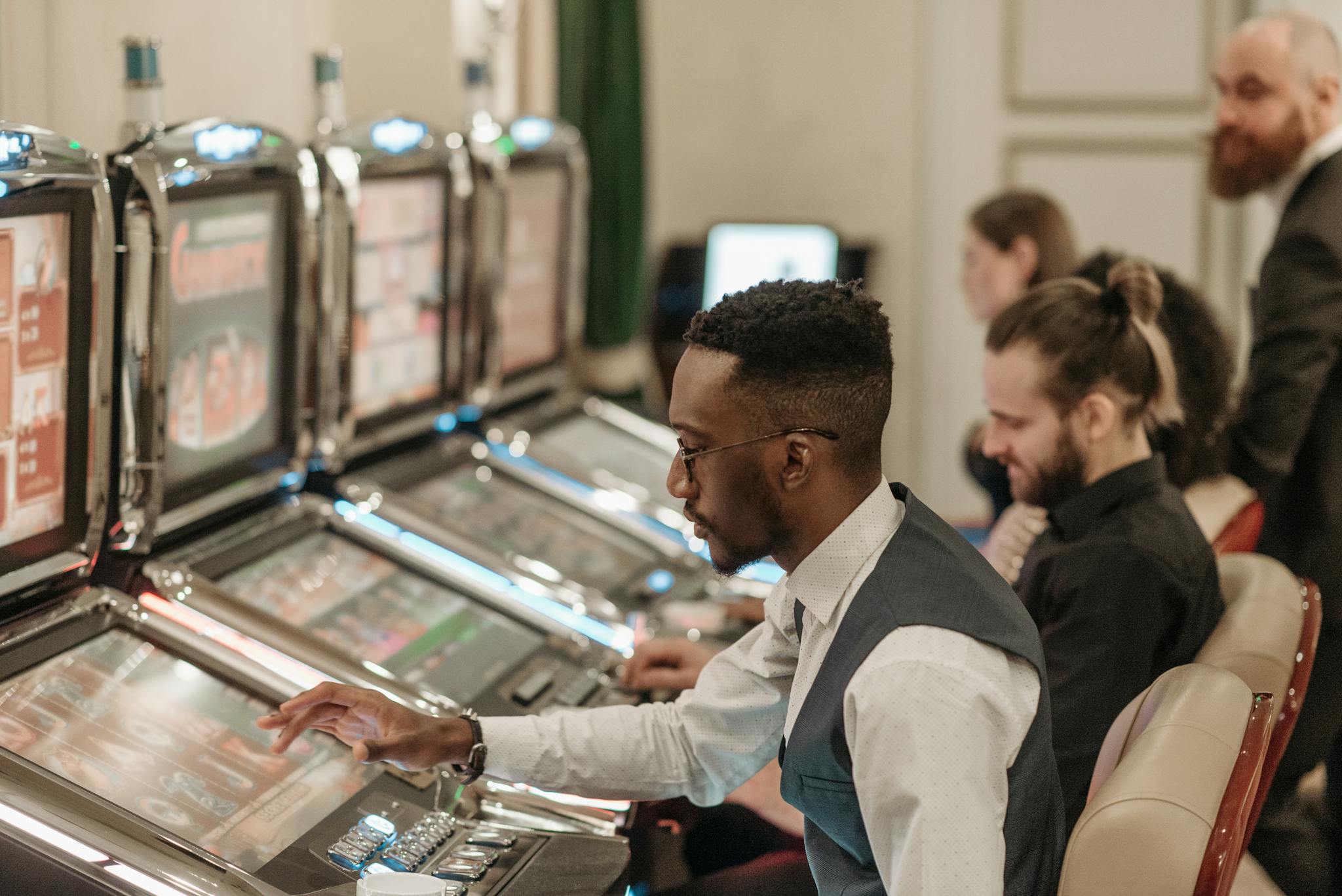 Group of men enjoying an evening at a casino, playing slot machines indoors.